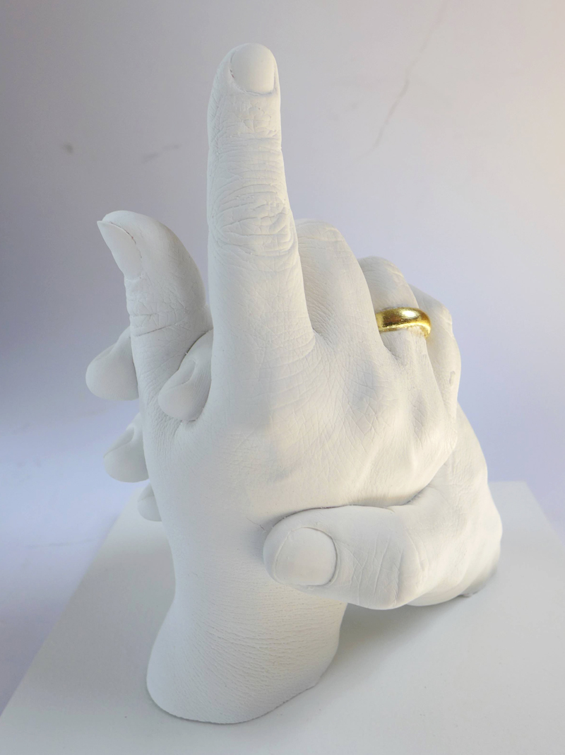 Foto des Abdrucks zweier Hände mit vergoldeten Ringen