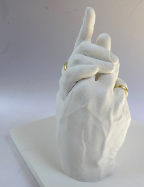 Zwei Hände mit vergoldeten Eheringen