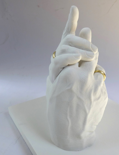 Zwei Hände mit vergoldeten Eheringen